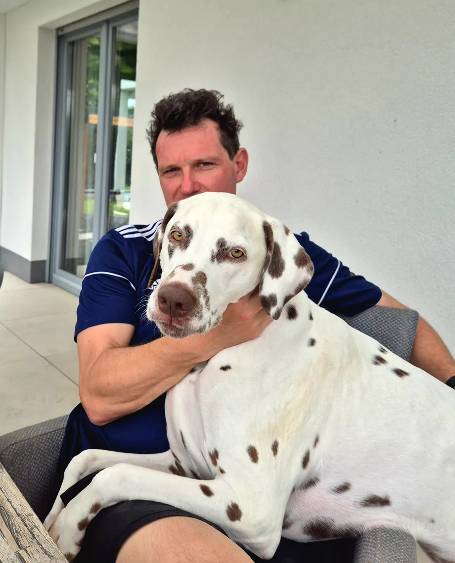 Bild zeigt Dr. med. Christoph Misch mit Praxishund Bounty